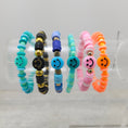 Load image into Gallery viewer, Smiley face stretch bracelets on rack.