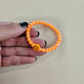 Load image into Gallery viewer, Orange smiley face stretch bracelet.
