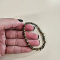 Load image into Gallery viewer, Black and gold stretch bracelet.