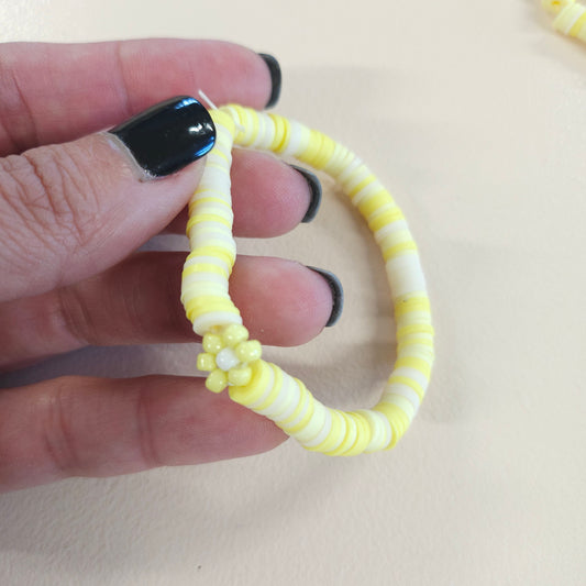 Yellow stretch friendship bracelet with flower.