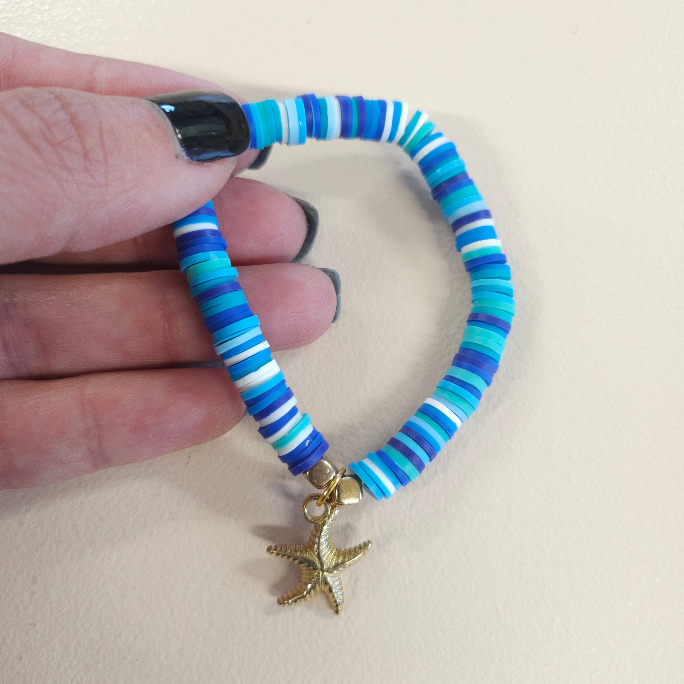 Blue stretch bracelet with gold starfish charm.