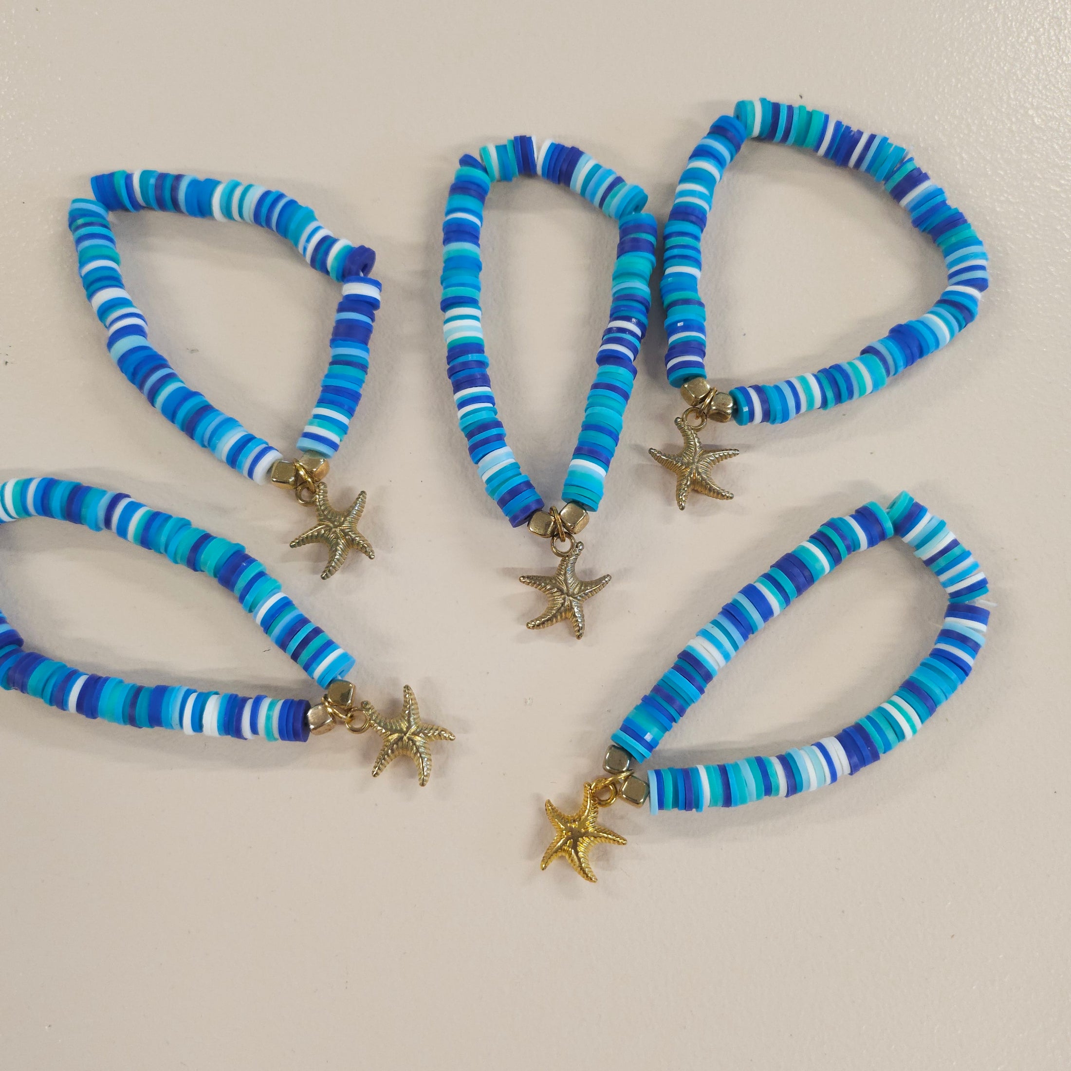 Blue friendship bracelets with gold starfish charm.