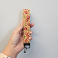 Load image into Gallery viewer, Hand holding a keychain with cherry design on a plain background