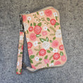 Load image into Gallery viewer, Floral patterned pouch with strap on a gray surface