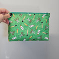 Load image into Gallery viewer, Green zipper pouch with school supplies shown on the outside.