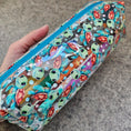 Load image into Gallery viewer, Pencil case with turtle pattern held by a hand on a gray surface