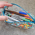Load image into Gallery viewer, Colorful pencil case with pens and markers on a textured surface