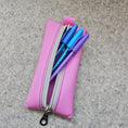 Load image into Gallery viewer, Pink pencil case with a zipper containing pens on a gray surface
