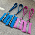 Load image into Gallery viewer, Two pink and two blue zipper pouches with wrist straps on a gray surface