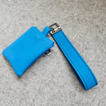 Load image into Gallery viewer, Blue leather wallet with strap on a gray surface
