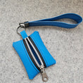 Load image into Gallery viewer, Blue keychain pouch with multiple zippers on a gray surface