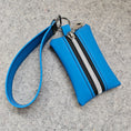 Load image into Gallery viewer, Blue wristlet with a zipper on a gray surface