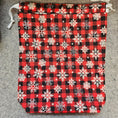 Load image into Gallery viewer, Red and black plaid gift bag with white snowflakes.
