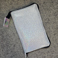 Load image into Gallery viewer, Silver glittery pouch with a strap on a gray surface