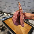 Load image into Gallery viewer, Hand holding a floral-patterned pot lid over an open grill.