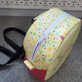 Load image into Gallery viewer, Top of the dear human behind me sling bag with white zipper and yellow vinyl with flowers and hearts.