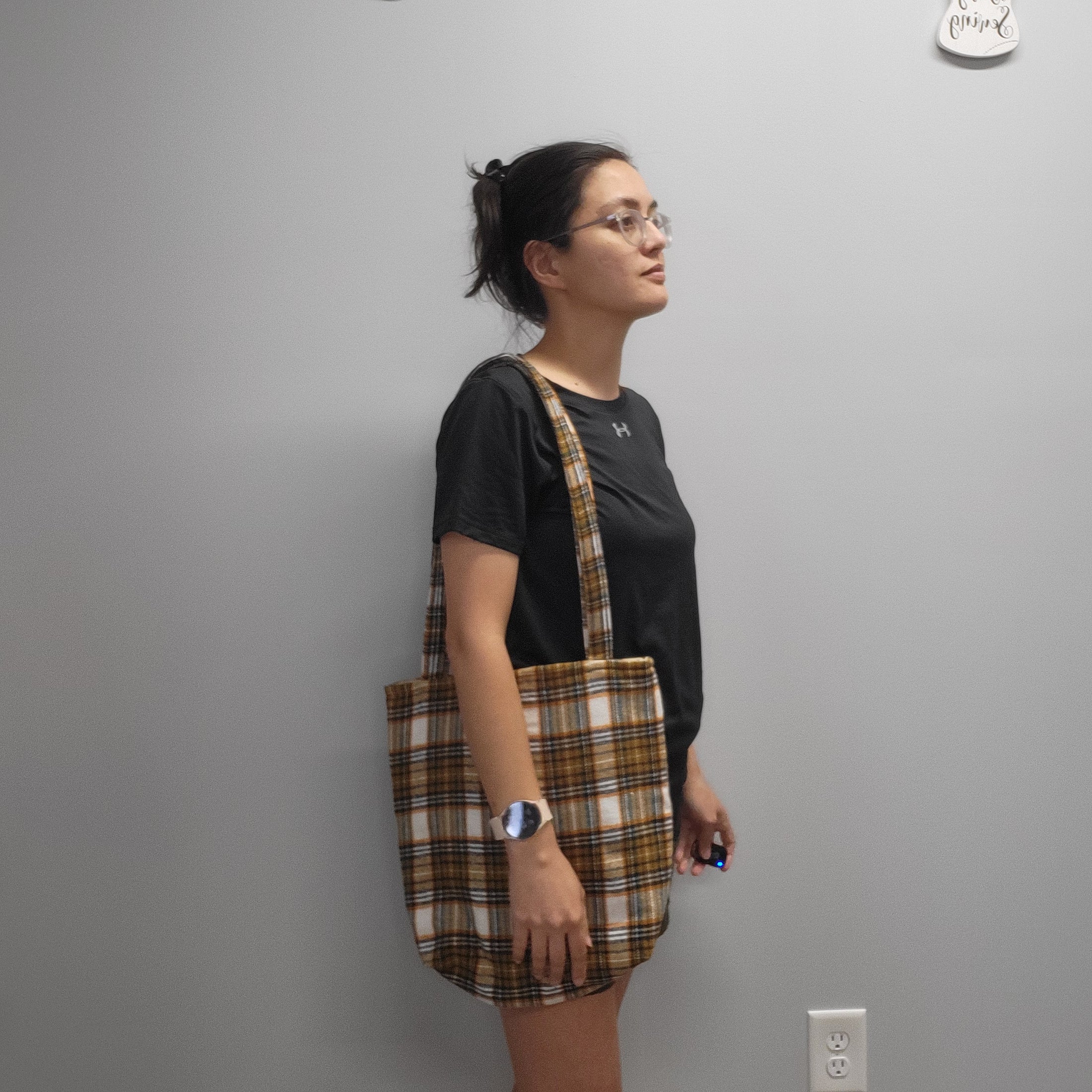Person wearing the soft flannel tote bag on the shoulder.