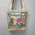 Load image into Gallery viewer, Bluebirds tote bag with birds, flowers, birdhouse and a butterfly.