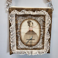 Load image into Gallery viewer, Close up view of the front of the purse with a lady wearing a birdcage skirt surrounded by lace.
