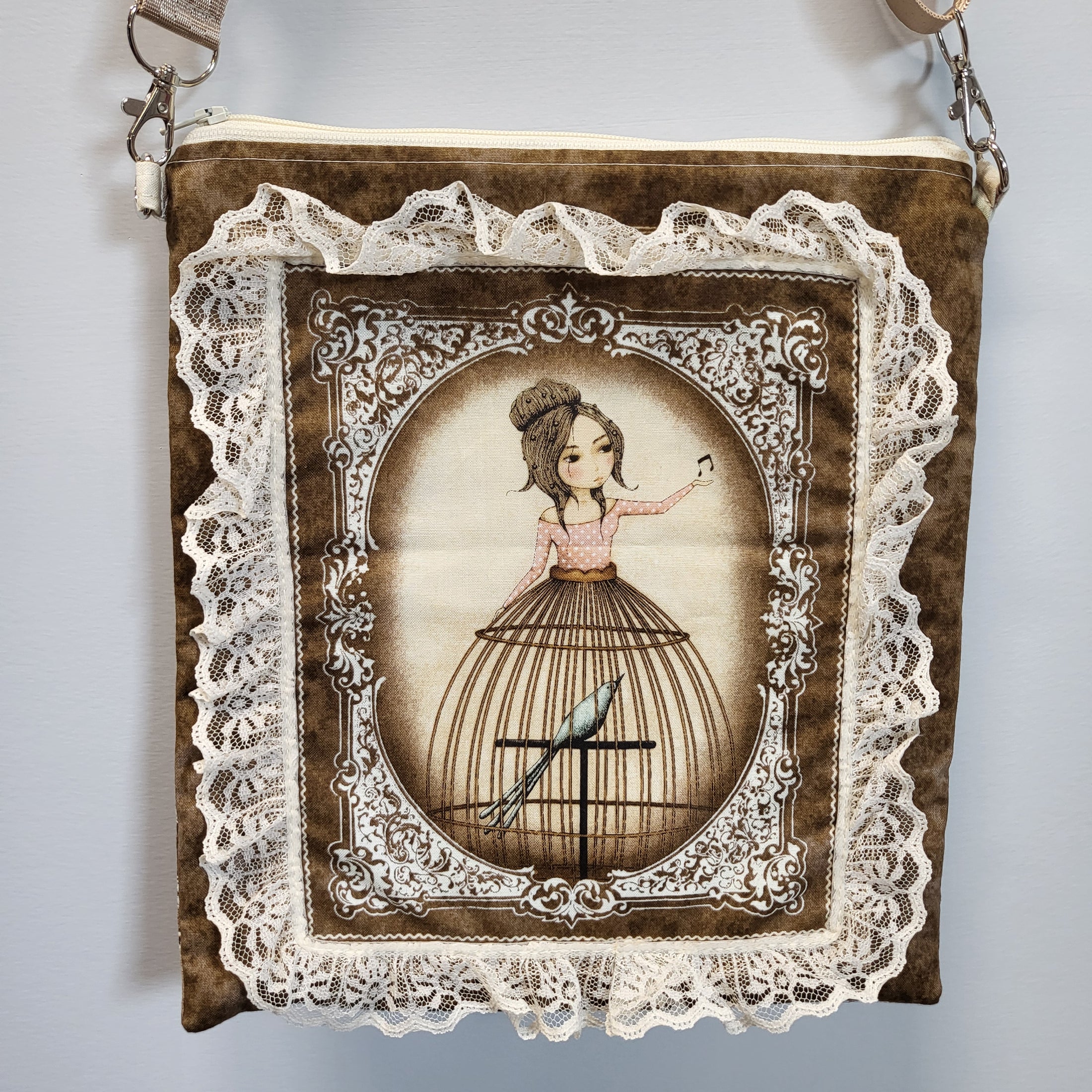 Close up view of the front of the purse with a lady wearing a birdcage skirt surrounded by lace.