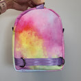 Load image into Gallery viewer, Back of the Mario Kart inspired bag featuring watercolor rainbow fabric and light purple polyester webbing.