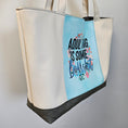 Load image into Gallery viewer, Tote bag with floral text design on a light blue background