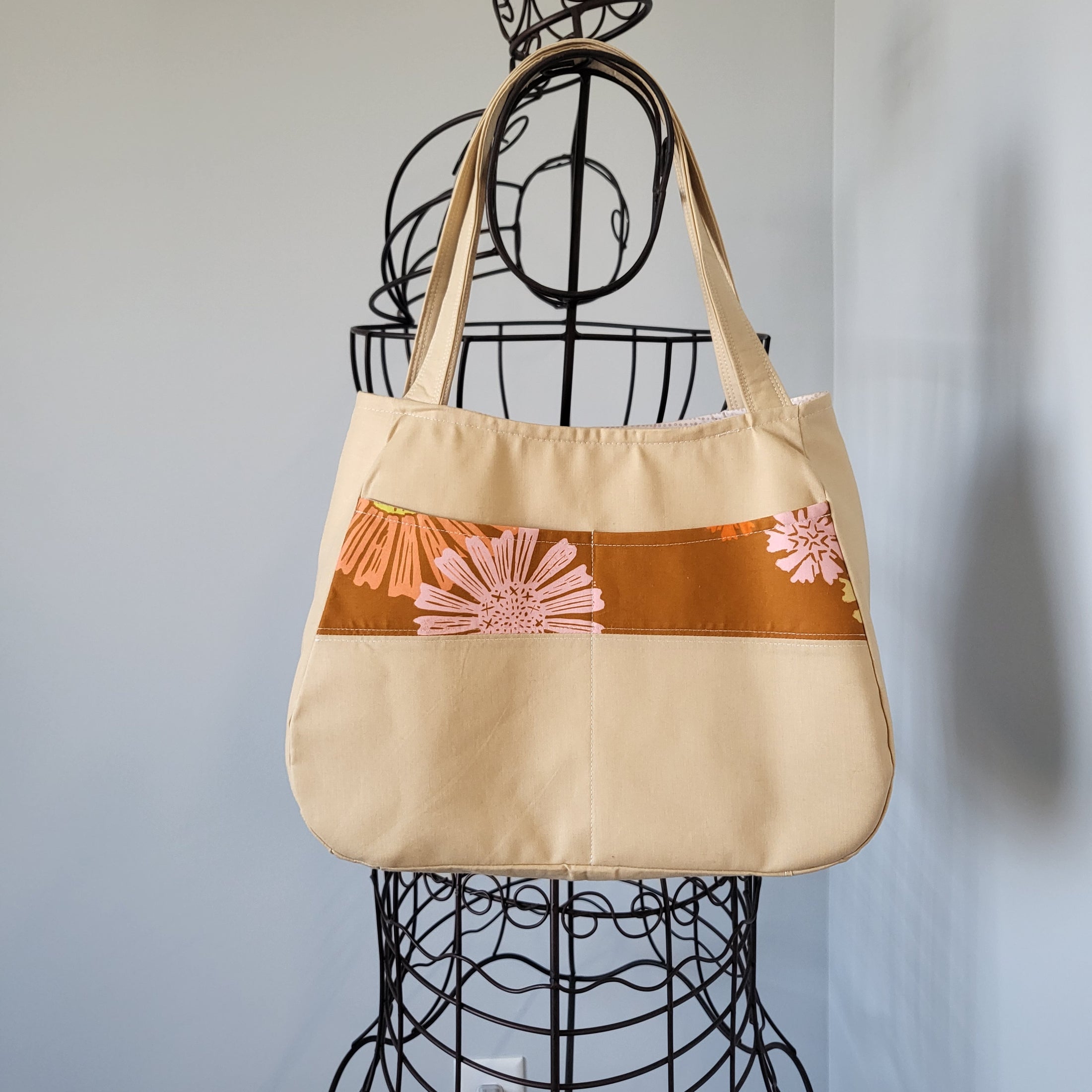 Let the sunshine in fabric tote bag hanging on metal dress form.