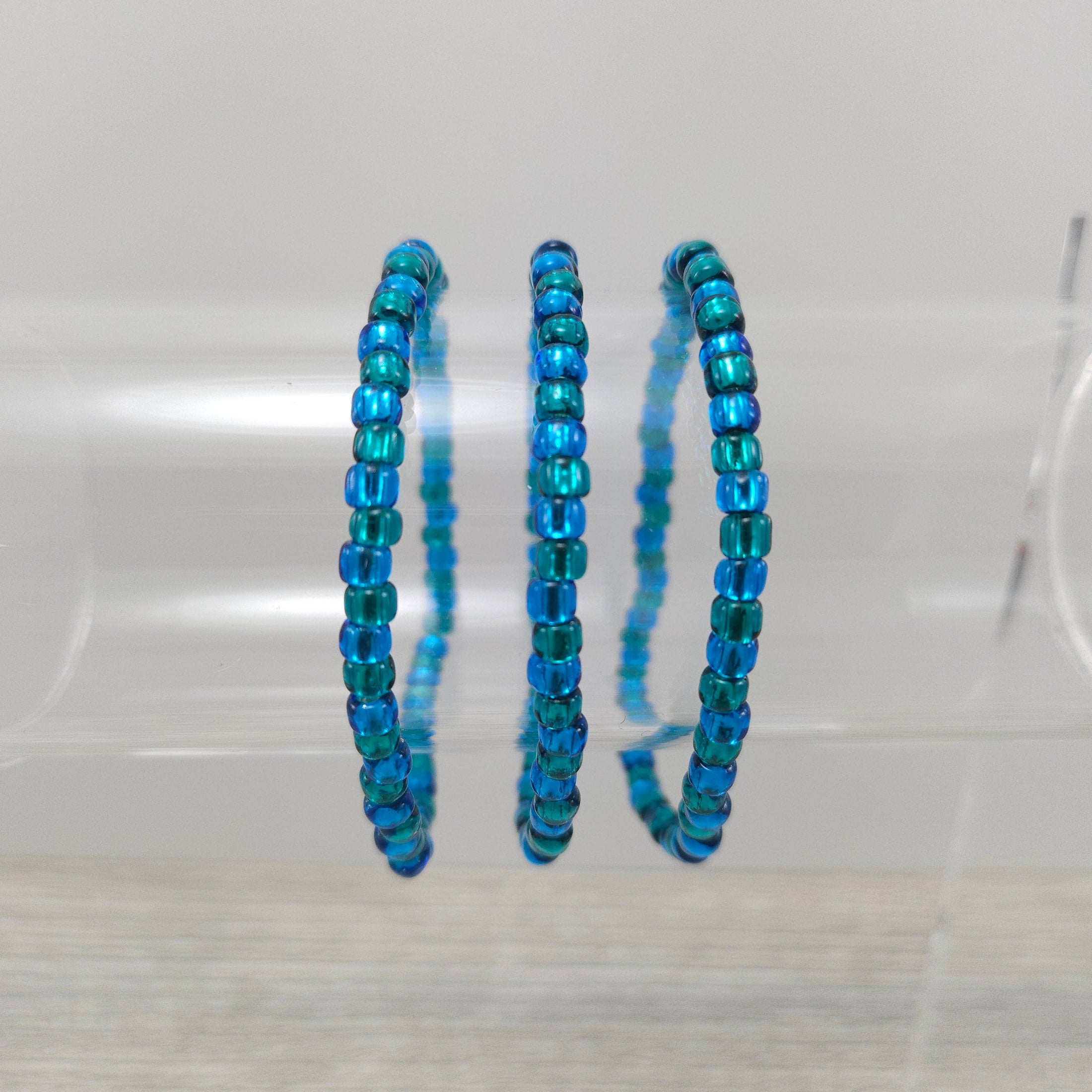 Ocean blue stretch bracelets on stand.