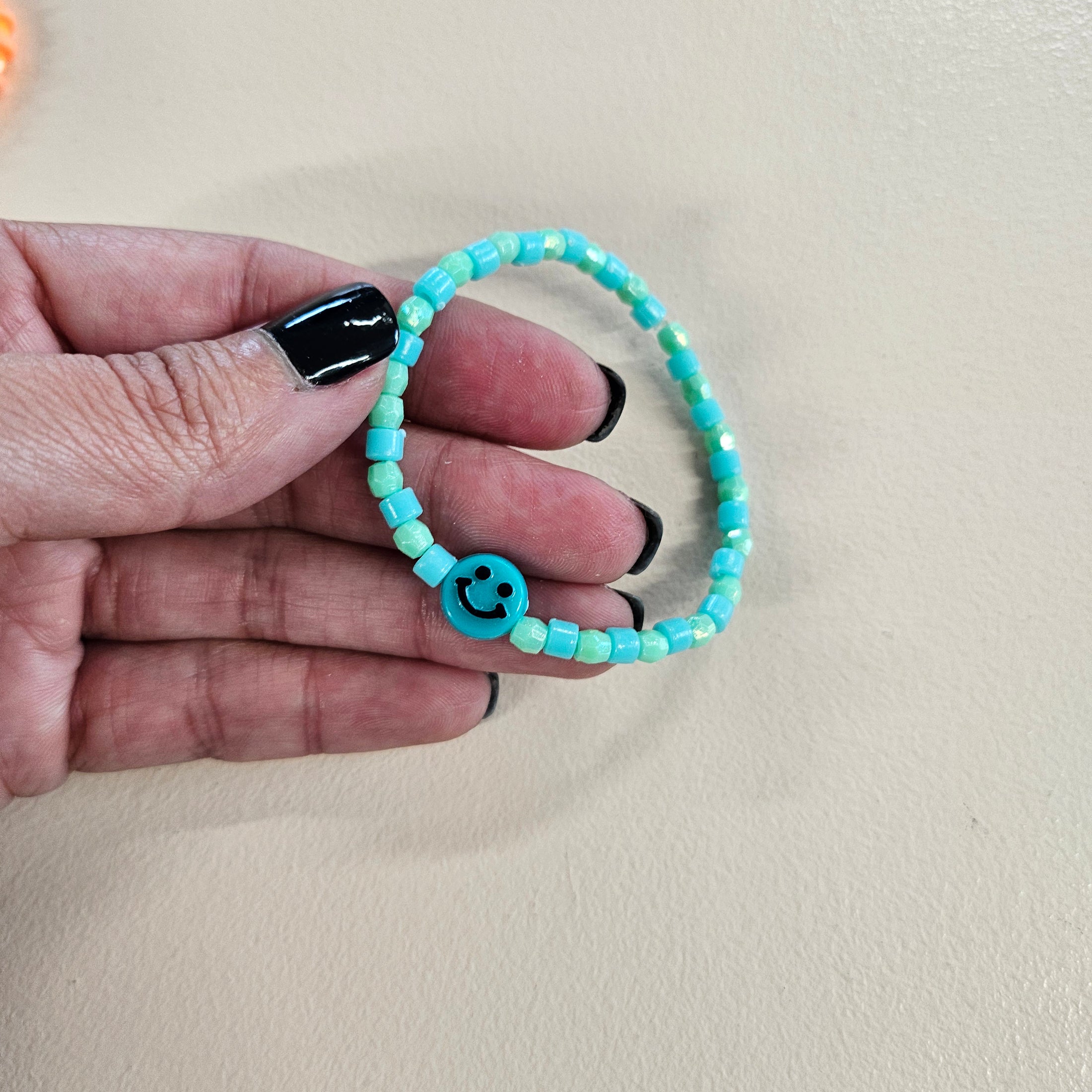 Blue green smiley face stretch bracelet.