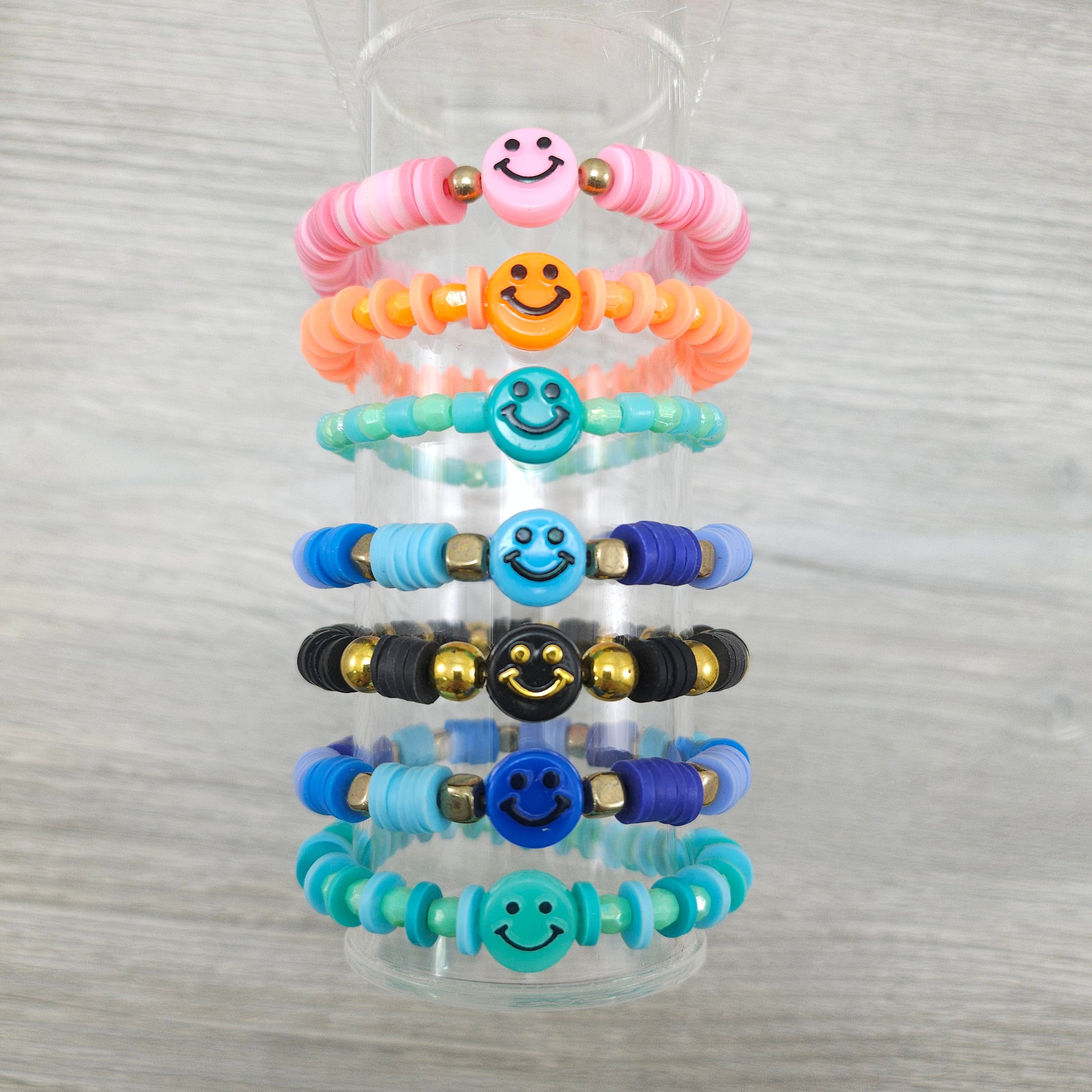 Smiley face stretch bracelets on stand.