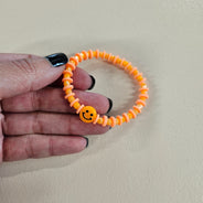 Orange smiley face stretch bracelet.