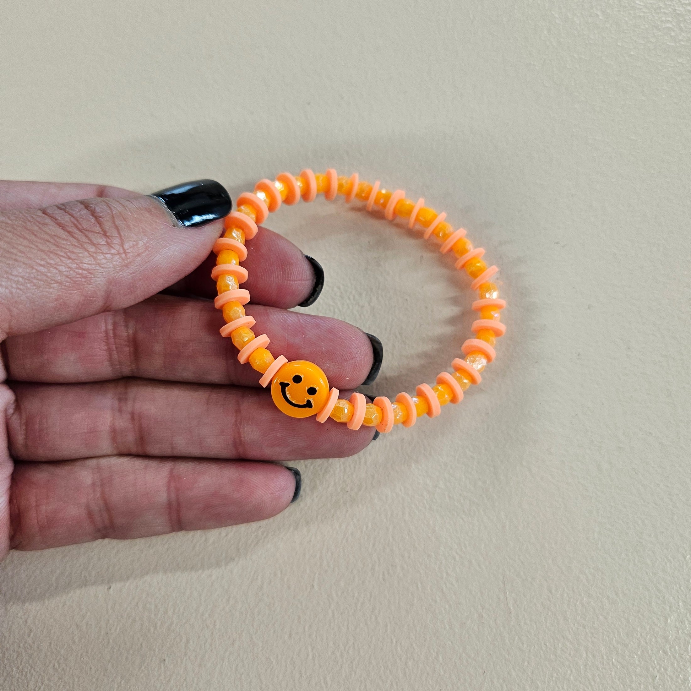 Orange smiley face stretch bracelet.