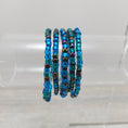 Load image into Gallery viewer, Mermaid tail stretch bracelets on rack.
