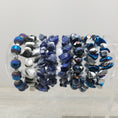 Load image into Gallery viewer, Rock stretch bracelets on stand. 
