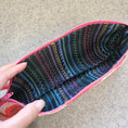 Load image into Gallery viewer, Lining fabric of the praise be bitches zipper pouch is black with multicolored stitch designs.
