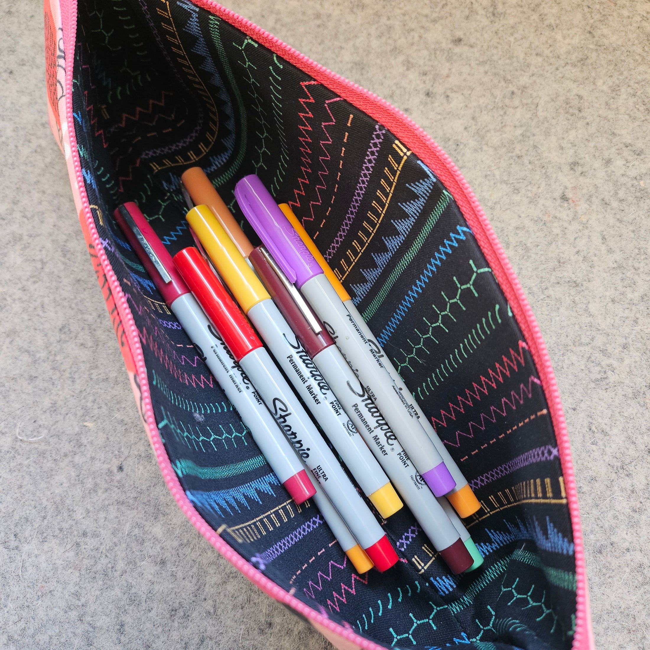 Praise be bitches zipper pouch filled with sharpie markers.