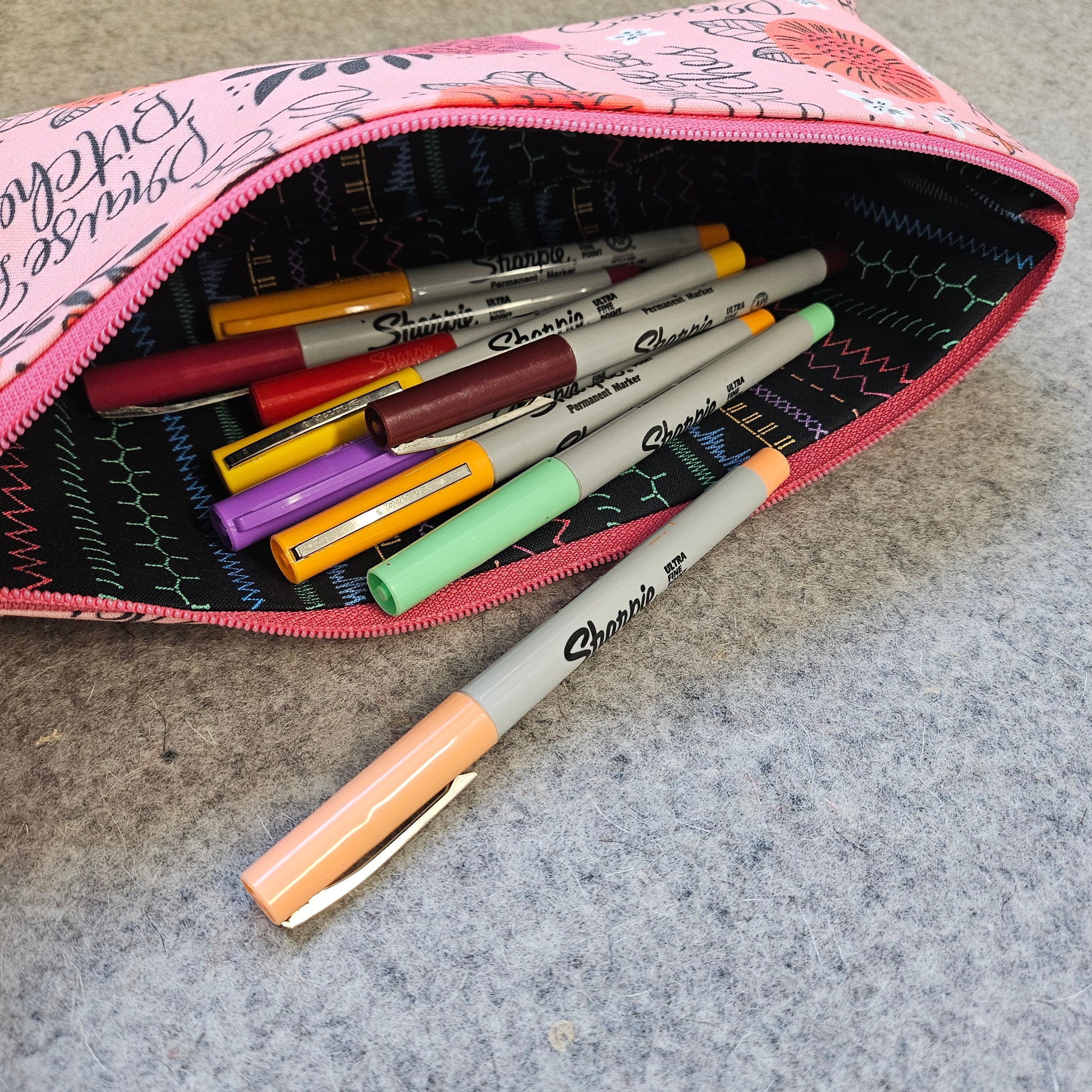 Praise be bitches zipper pouch laying on its side with markers.