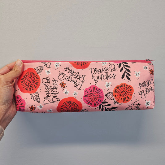 Praise be bitches zipper pouch on a light gray background.