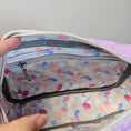 Load image into Gallery viewer, Colorful polka dot bag with a hand opening it on a gray background
