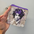 Load image into Gallery viewer, Hand holding a small pouch with a printed design on a plain background
