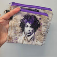 Load image into Gallery viewer, Hand holding a wallet with a purple zipper and artistic design on the cover.
