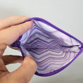 Load image into Gallery viewer, Purple wallet with a patterned interior held open by hands against a neutral background
