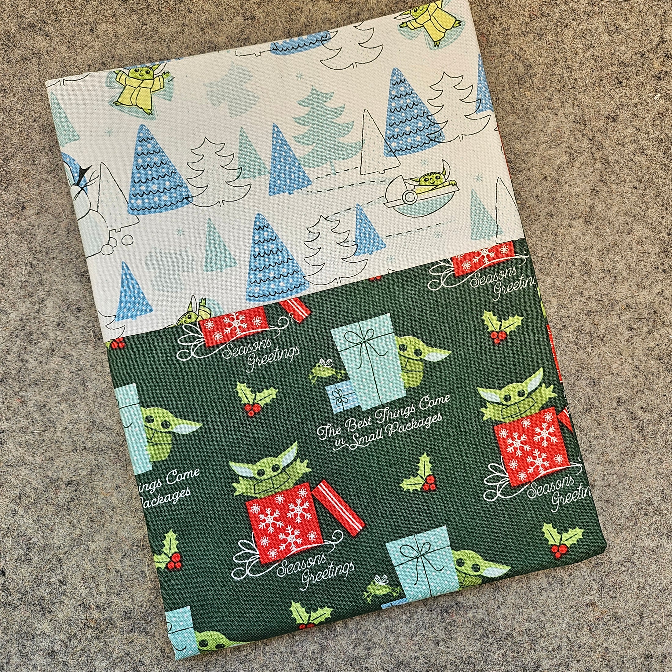 Two fabric swatches with Christmas-themed patterns on a textured surface.