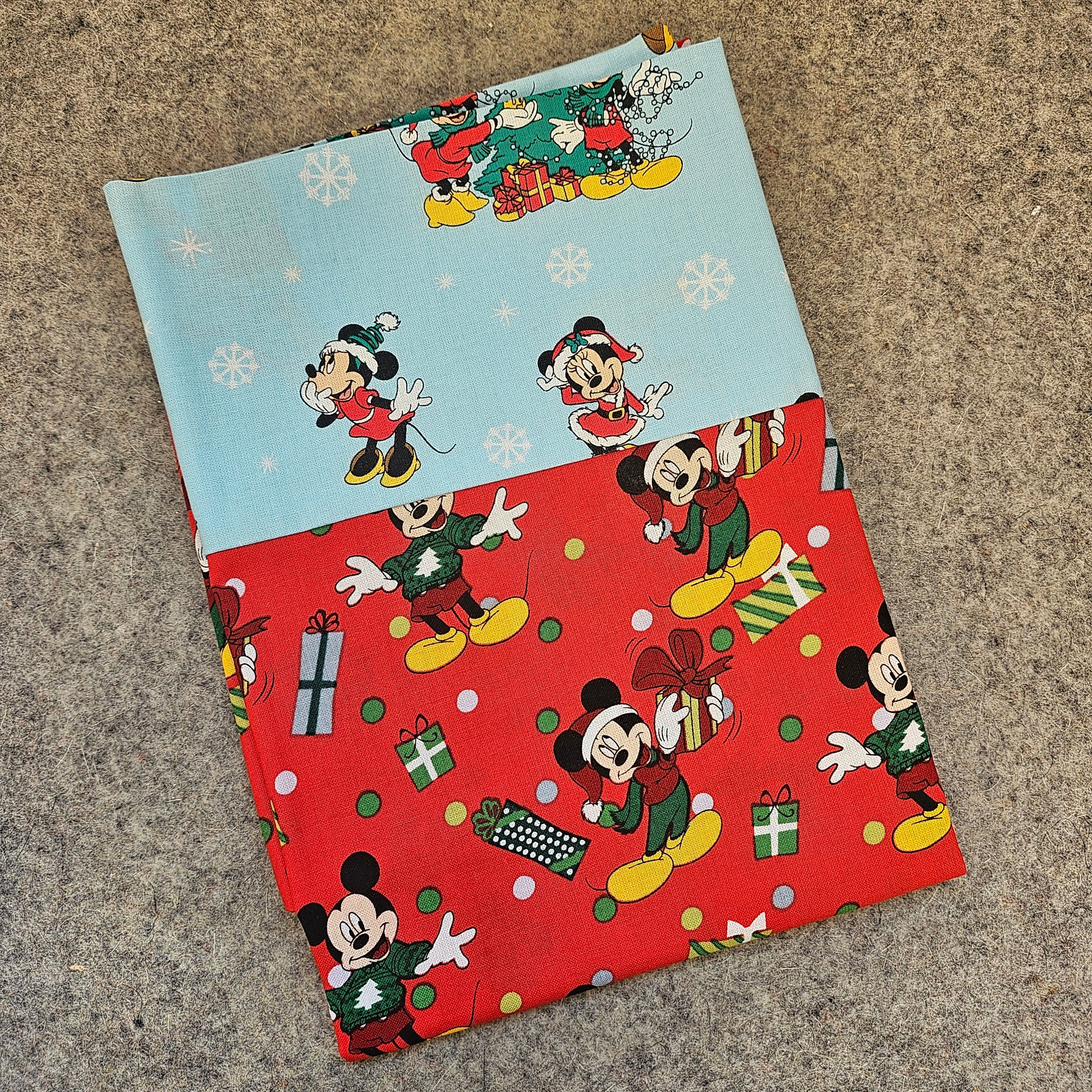 Two fabric swatches with Mickey Mouse designs on a textured surface