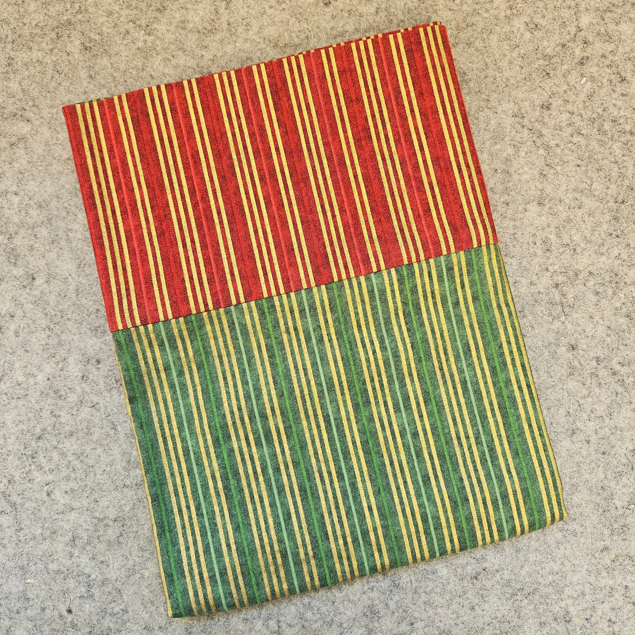 Striped red and green rug on a concrete floor