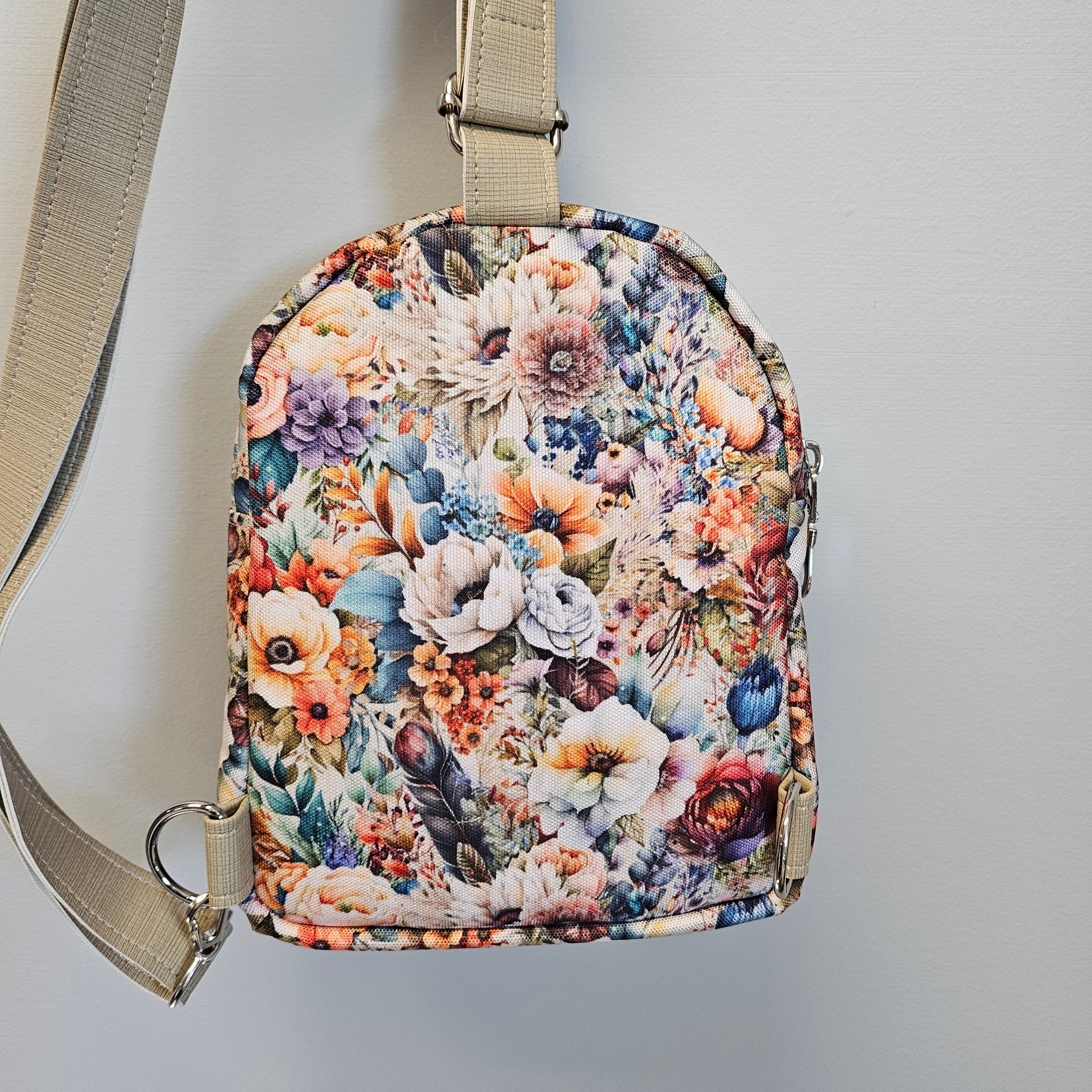 Floral patterned bag with beige strap on a light gray background