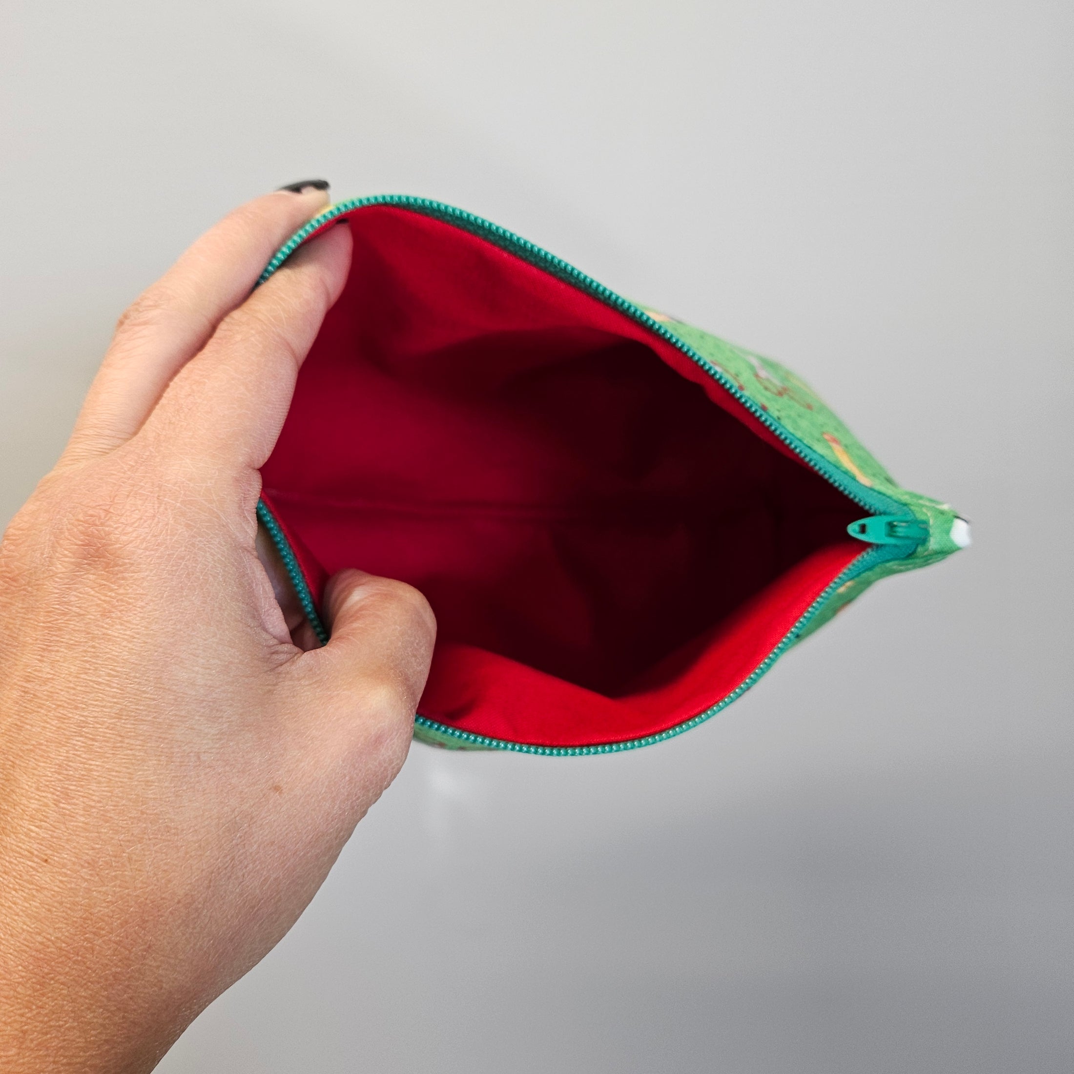 Inside view of the red lining of the school essentials zipper storage pouch.