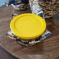 Load image into Gallery viewer, Yellow lid on a patterned fabric bowl cozy on a wooden surface
