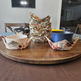 Load image into Gallery viewer, Decorative floral-patterned bowl cozies on a wooden surface with a blurred background.
