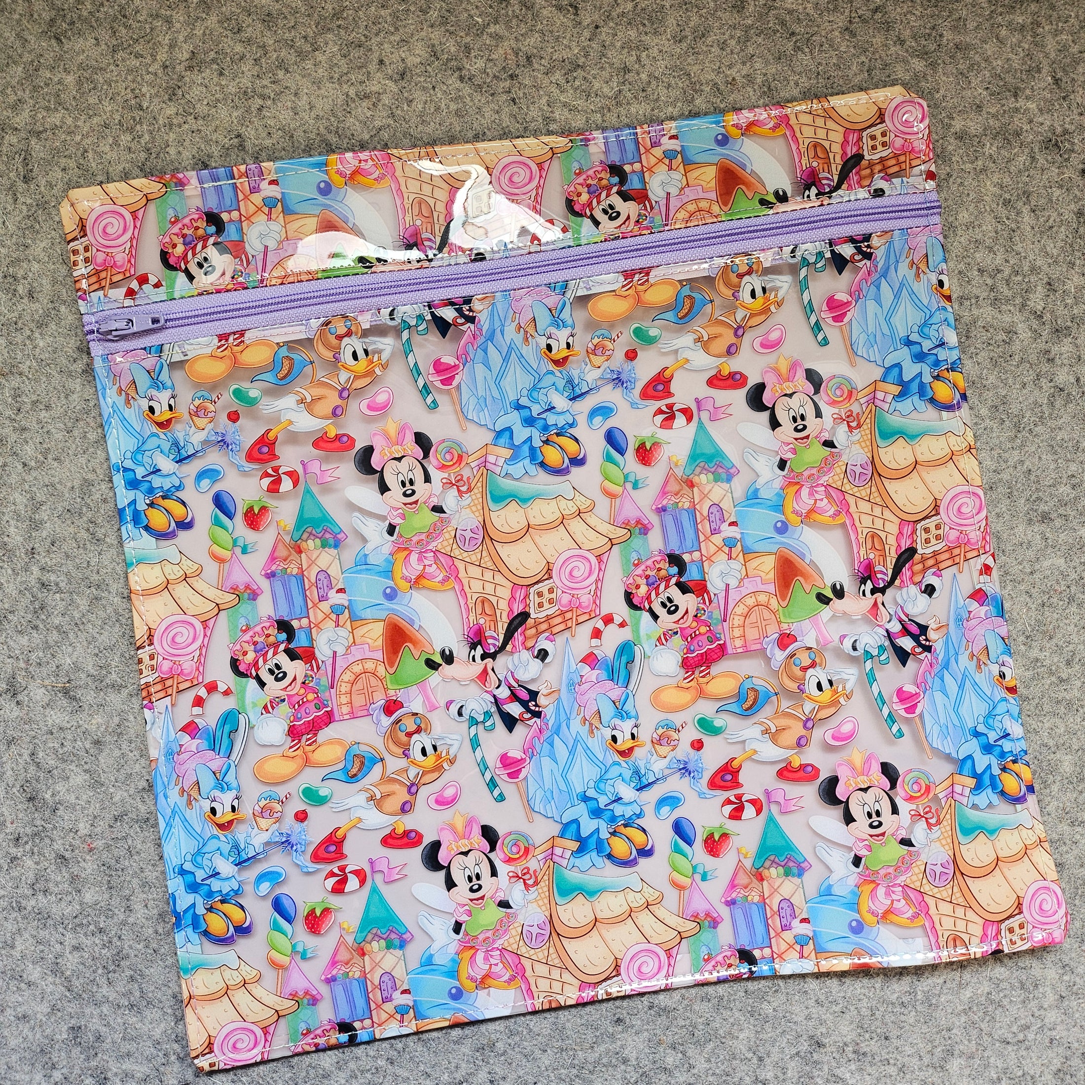 Colorful Disney-themed folder with character patterns on a gray surface